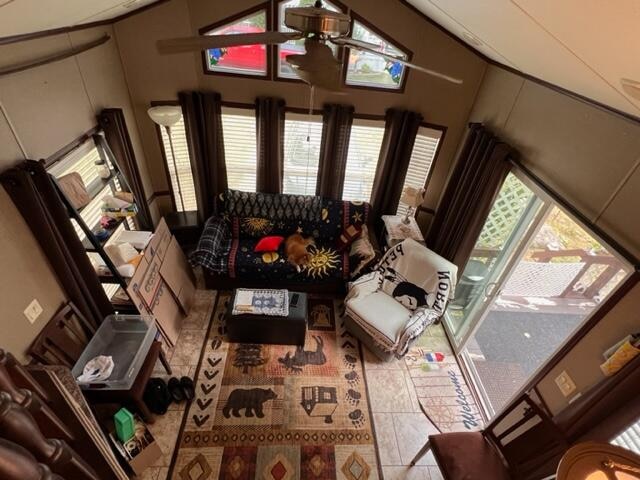 tiled living room featuring a high ceiling and ceiling fan