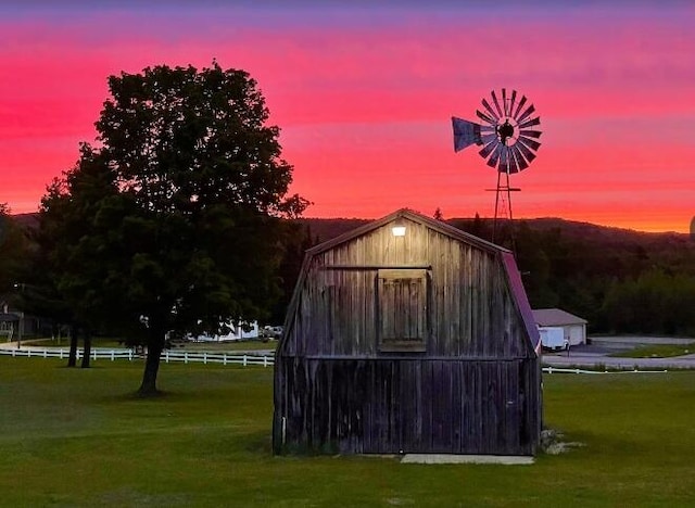 outdoor structure at dusk featuring a yard