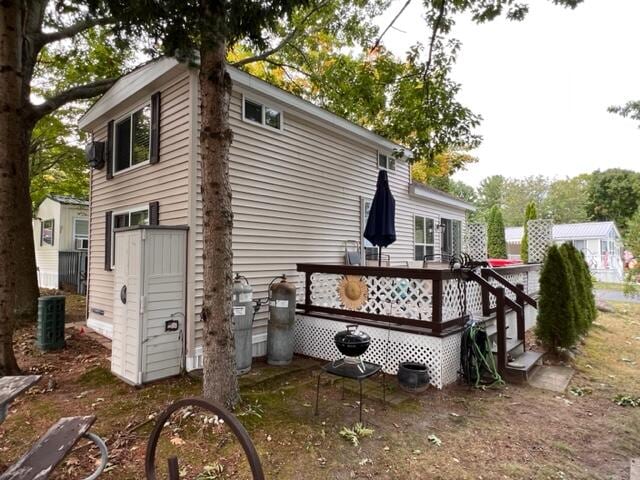 view of side of property with a deck and cooling unit