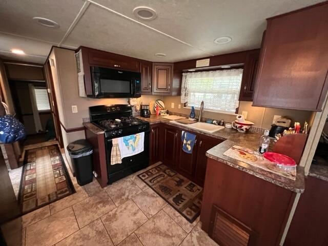 kitchen featuring black appliances, sink, and light tile patterned flooring