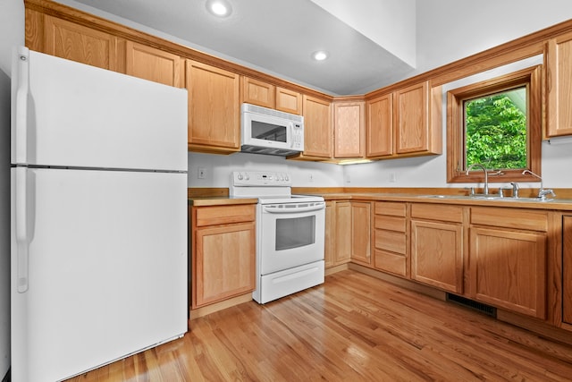 kitchen with white appliances, sink, and light hardwood / wood-style flooring