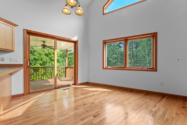 unfurnished room with an inviting chandelier and light hardwood / wood-style flooring