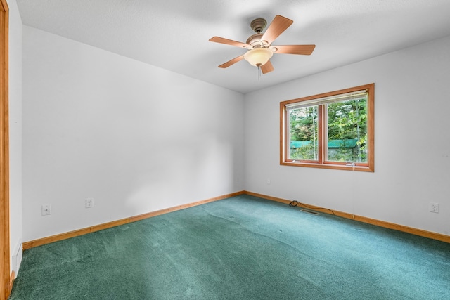 carpeted spare room featuring ceiling fan