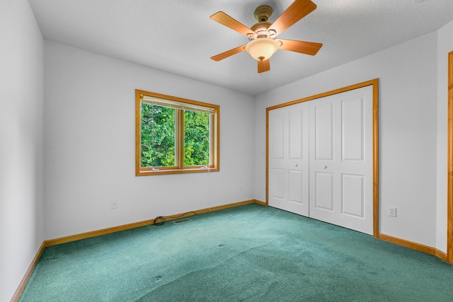 unfurnished bedroom with a textured ceiling, ceiling fan, a closet, and carpet floors