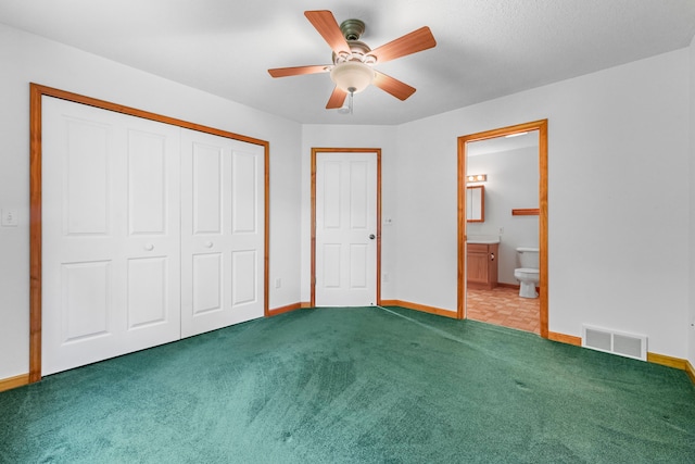 unfurnished bedroom featuring a closet, ceiling fan, connected bathroom, and carpet floors