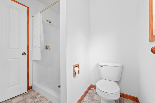 bathroom featuring toilet and a shower with shower curtain