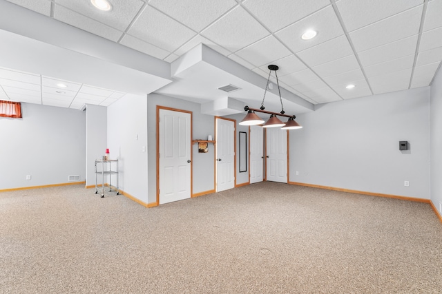 basement with a paneled ceiling and carpet floors