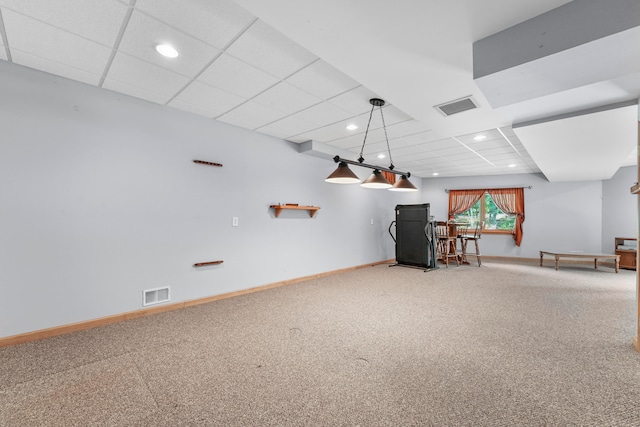 interior space with a paneled ceiling and carpet flooring