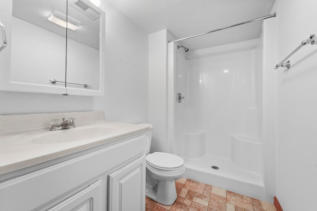 bathroom featuring a shower, toilet, a textured ceiling, and vanity