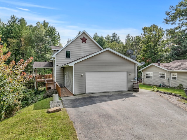 front of property featuring a wooden deck, a garage, and a front yard