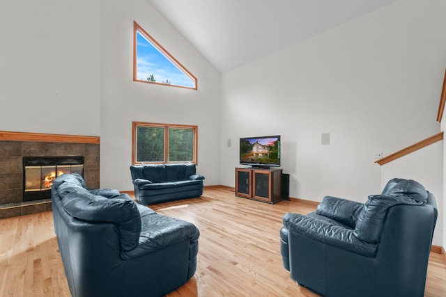 living room with plenty of natural light, a tiled fireplace, and hardwood / wood-style flooring