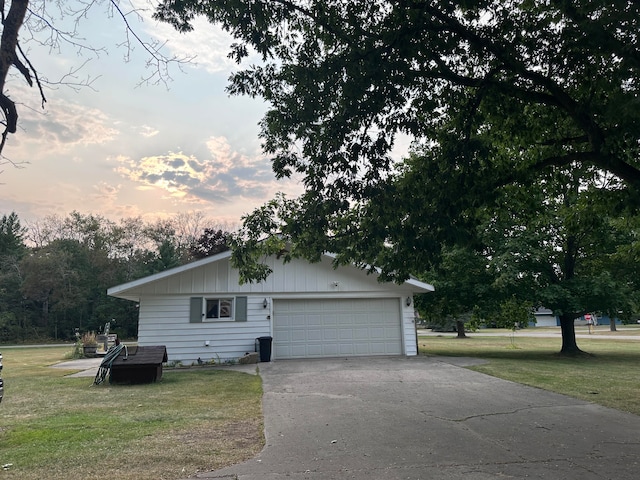 property exterior at dusk featuring a garage and a lawn