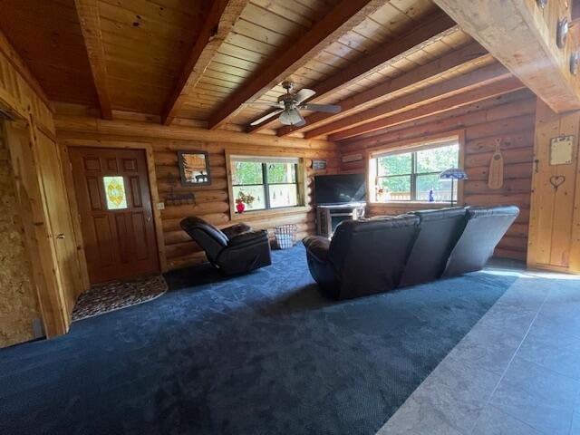 unfurnished living room featuring ceiling fan, wood ceiling, beam ceiling, and log walls