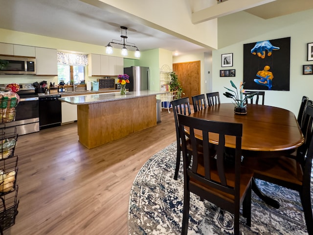 dining area with sink and light wood-type flooring