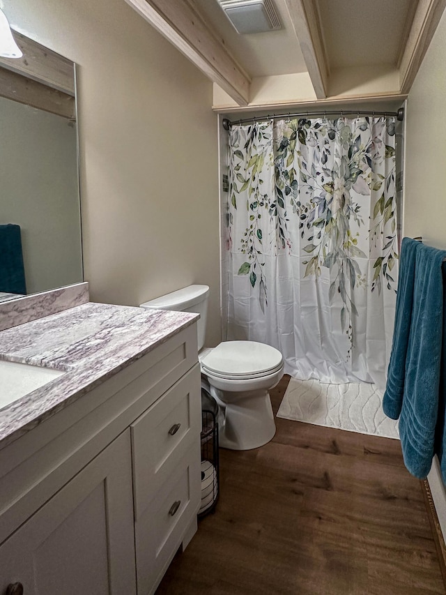 bathroom featuring hardwood / wood-style flooring, vanity, beamed ceiling, a shower with curtain, and toilet