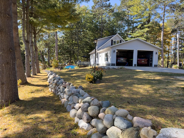 view of property exterior with a garage, an outdoor structure, and a lawn