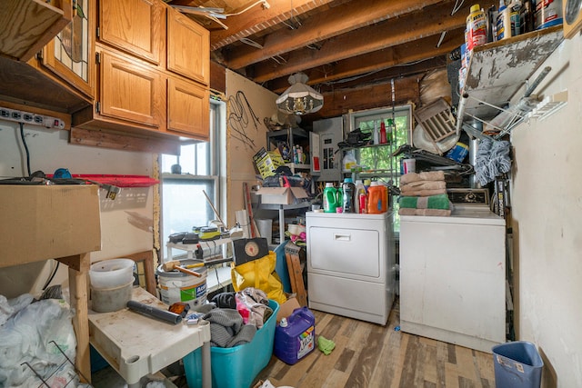 basement featuring electric panel, washer and clothes dryer, and light wood-type flooring