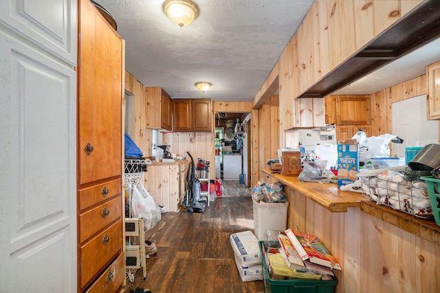 kitchen with wooden walls and dark hardwood / wood-style flooring