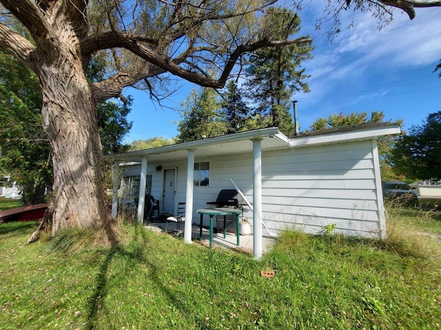 back of house with a lawn and a patio area