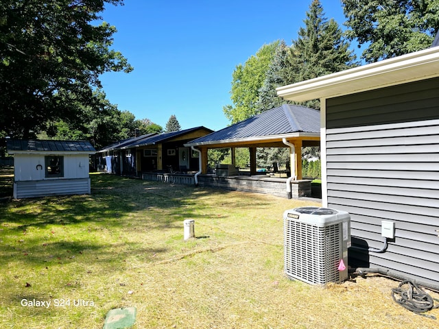 view of yard featuring a gazebo, a storage unit, and central air condition unit