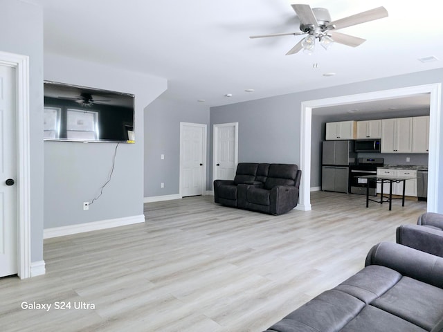 living room with light wood-type flooring and ceiling fan