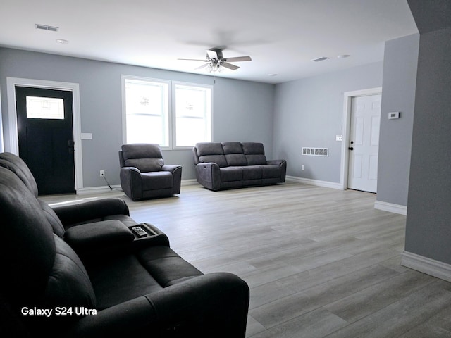 living room with ceiling fan and light wood-type flooring