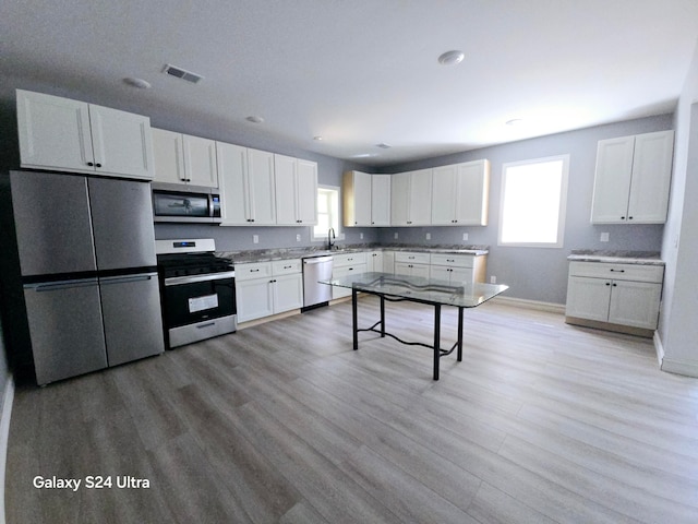 kitchen featuring light hardwood / wood-style flooring, stainless steel appliances, white cabinets, and sink