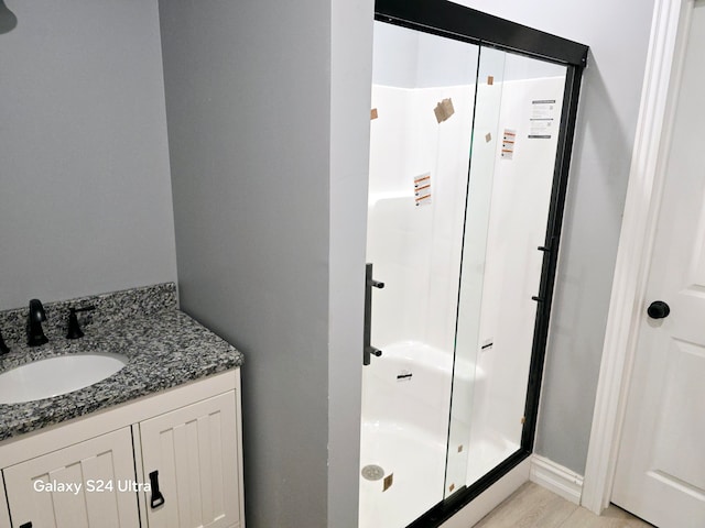 bathroom featuring walk in shower and vanity