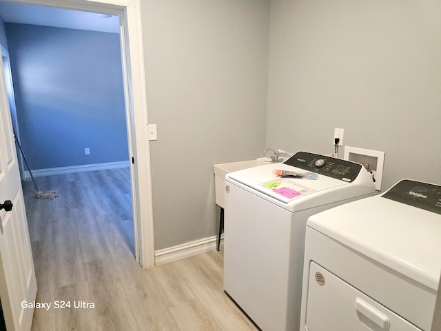 laundry area featuring washer and clothes dryer and light wood-type flooring