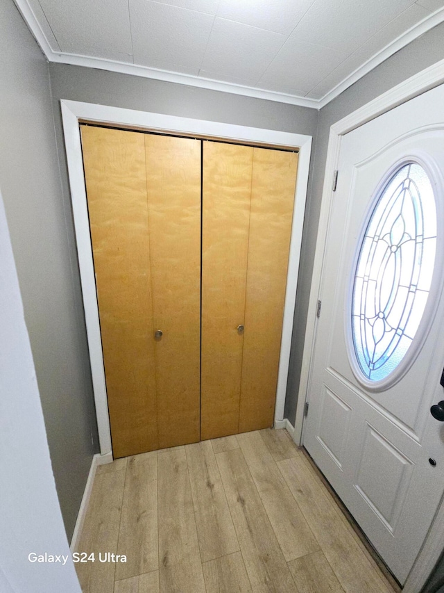 entrance foyer featuring light hardwood / wood-style flooring and crown molding