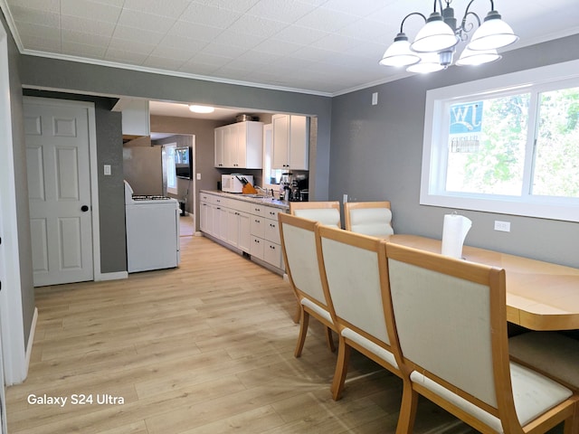 dining area featuring crown molding, light hardwood / wood-style floors, and a notable chandelier