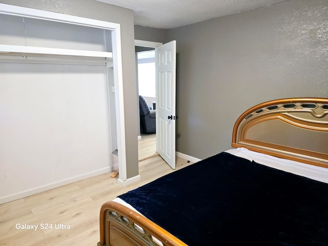 unfurnished bedroom featuring wood-type flooring, a closet, and a textured ceiling