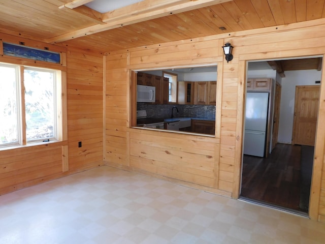 interior space featuring wood walls, beamed ceiling, and wooden ceiling