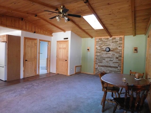 unfurnished dining area with carpet, lofted ceiling with skylight, ceiling fan, and wood ceiling