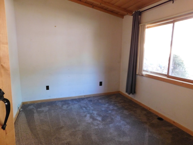 empty room with carpet floors and wood ceiling