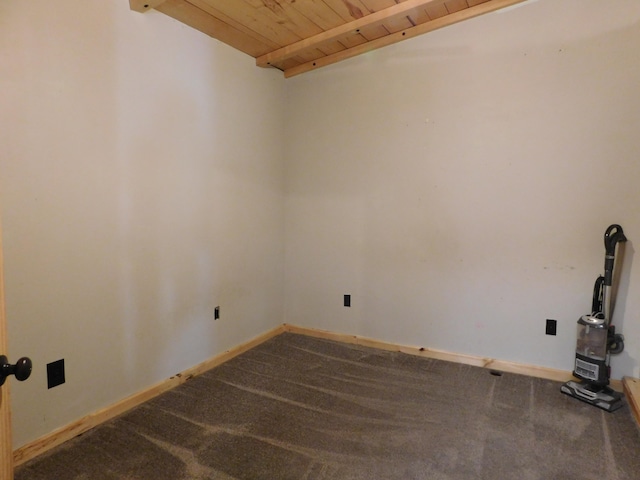 unfurnished room with beam ceiling, carpet floors, and wood ceiling