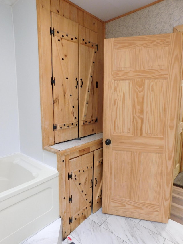 bathroom featuring a bathing tub and crown molding