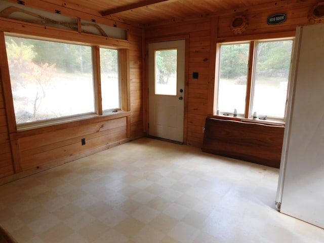 unfurnished sunroom featuring a wealth of natural light and wood ceiling