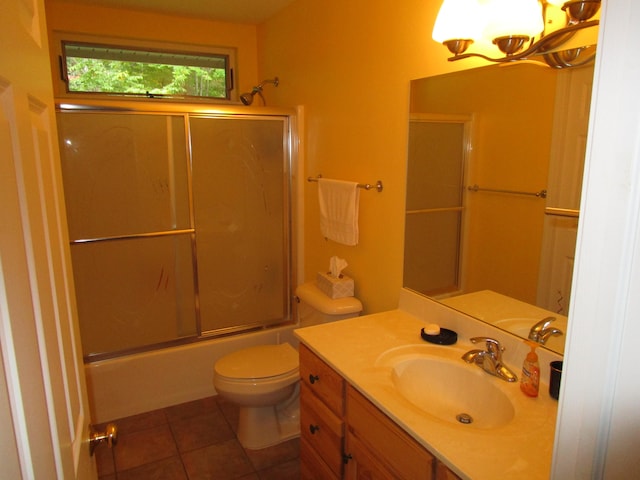 full bathroom featuring combined bath / shower with glass door, vanity, toilet, and tile patterned floors