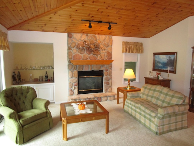 living room with rail lighting, a stone fireplace, carpet flooring, and wooden ceiling