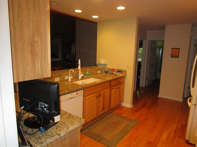 kitchen with light stone countertops, dishwasher, light hardwood / wood-style floors, and sink