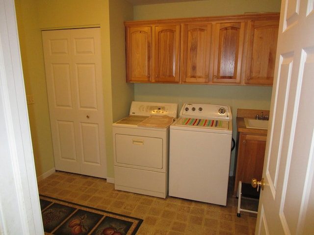 washroom with cabinets, sink, and washing machine and clothes dryer