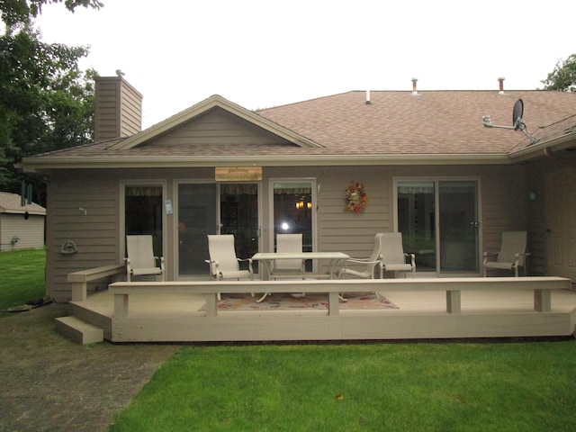 back of house with a wooden deck and a yard