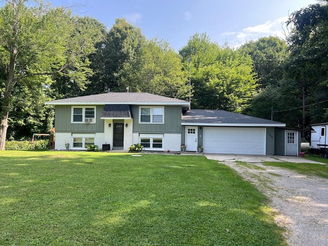 split foyer home featuring a front lawn, central AC unit, and a garage