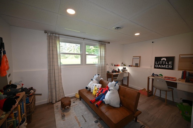 interior space with a drop ceiling and hardwood / wood-style floors