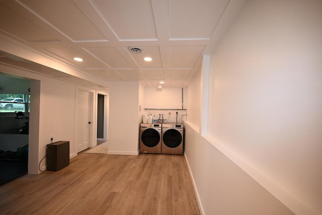 interior space with washing machine and clothes dryer, coffered ceiling, and light hardwood / wood-style flooring