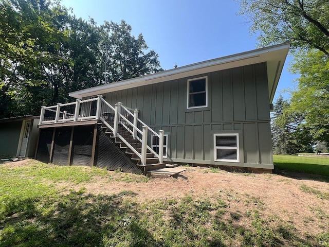 back of house featuring a lawn and a deck