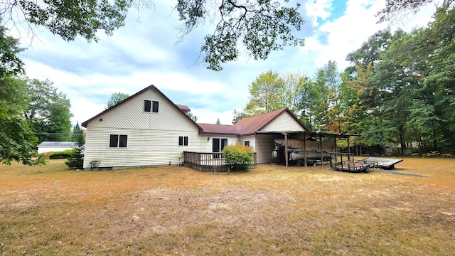 rear view of property with a lawn and a deck