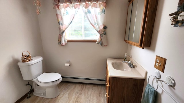 bathroom with hardwood / wood-style flooring, vanity, toilet, and a baseboard radiator