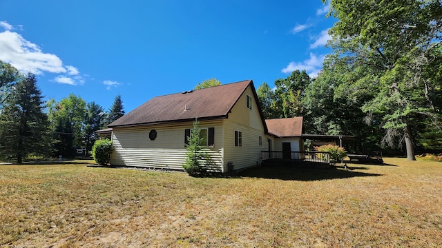 view of home's exterior with a deck and a yard